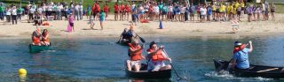 teams of two rowing boats with onlookers cheering